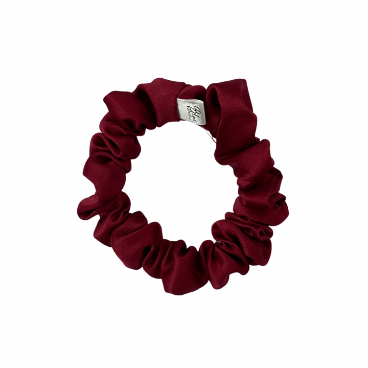 A red matte satin skinny scrunchie displayed on a white background.