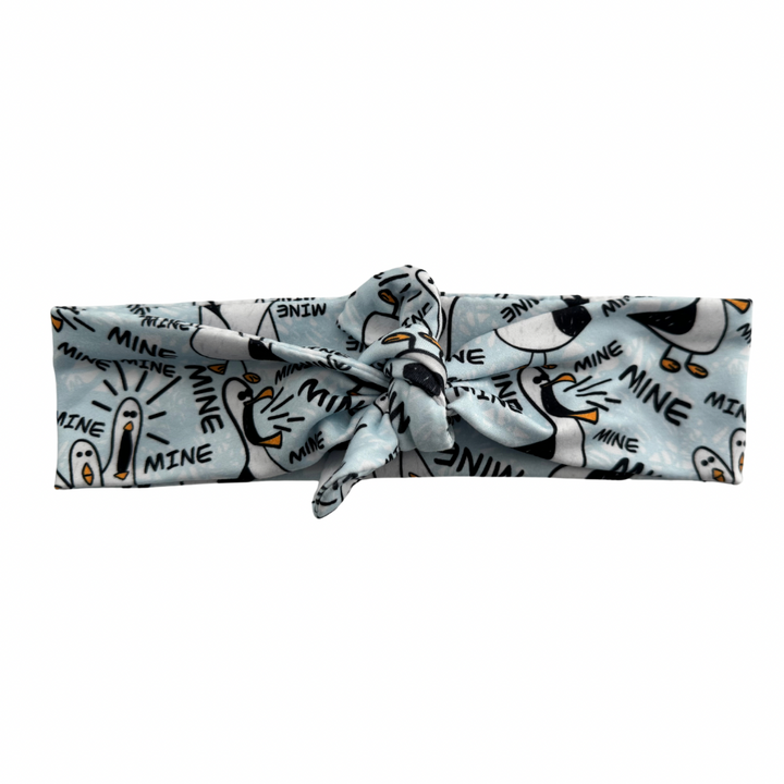 A tie headband with a pattern of birds and the text &