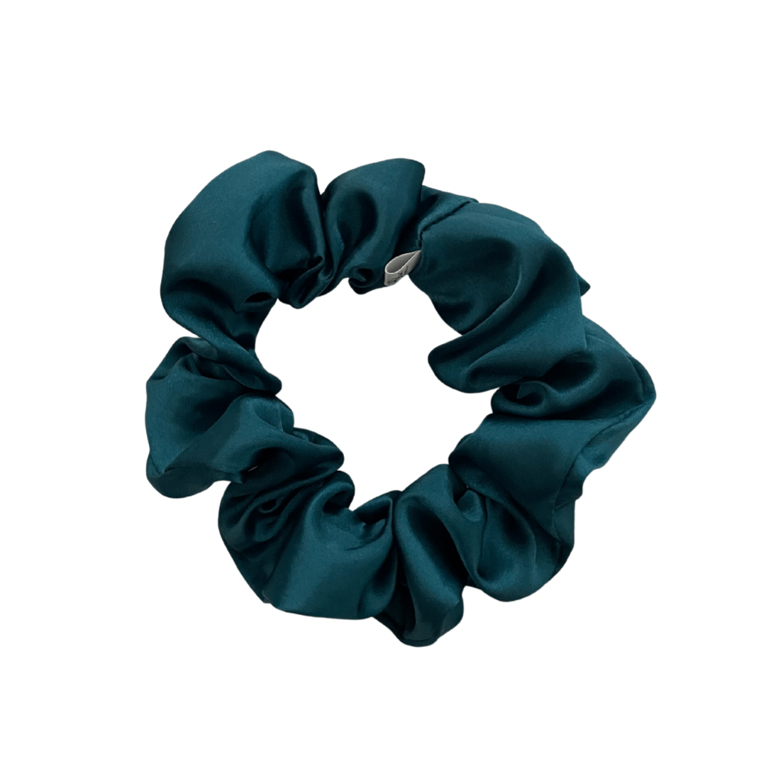 A deep teal satin scrunchie isolated on a white background.