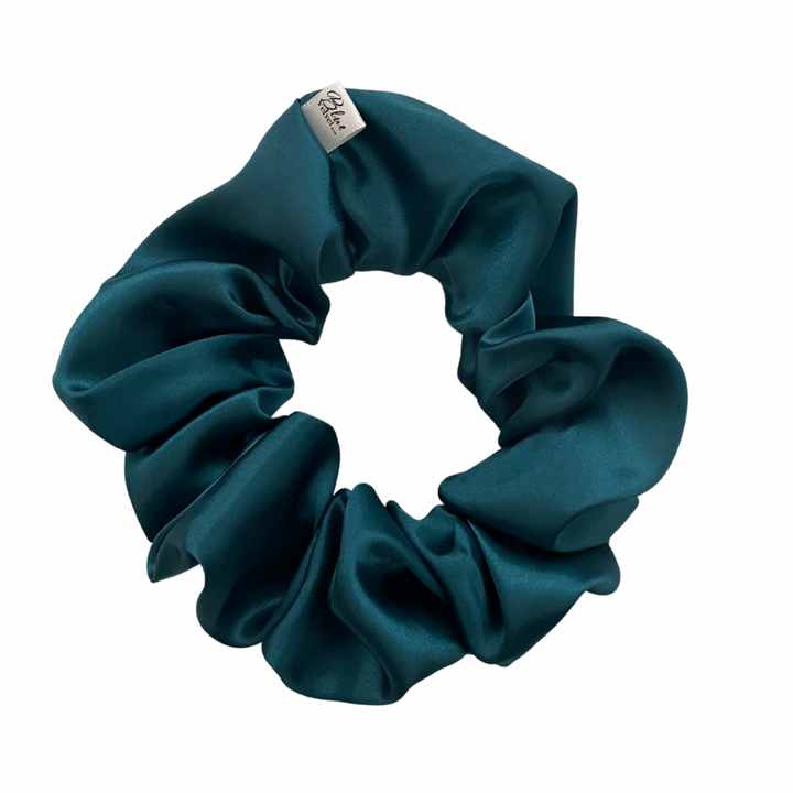 A deep teal satin scrunchie displayed on a white background.